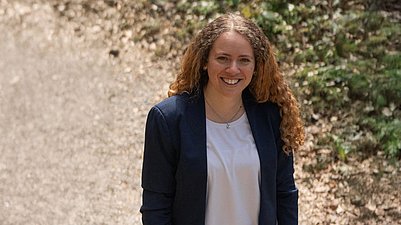 Frau steht draussen in der Natur