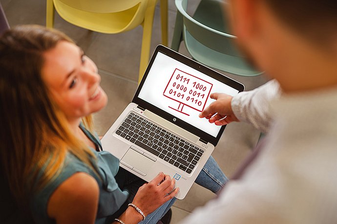 Zwei Studenten besprechen die Wichtigkeit in der Planung und Entwicklung von Softwaresystemen.