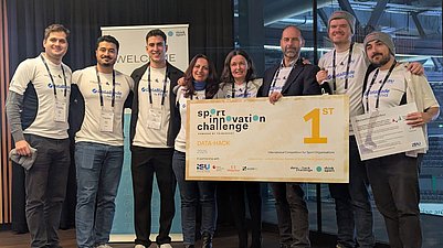 Gruppe hält Gewinntafel hoch