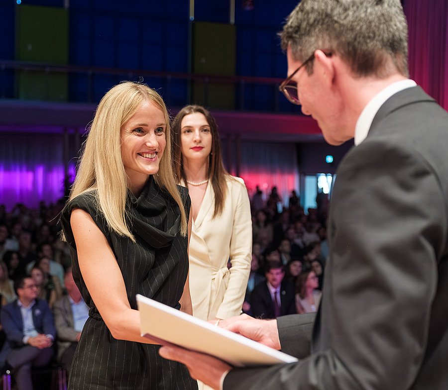 Rektor Marc Schnyder übergibt das Diplom