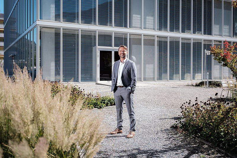 Tobais Häberlein steht vor dem Campus Brig.