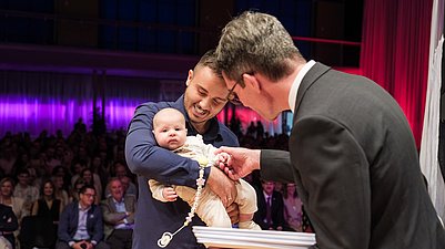 Student mit Baby holt Diplom