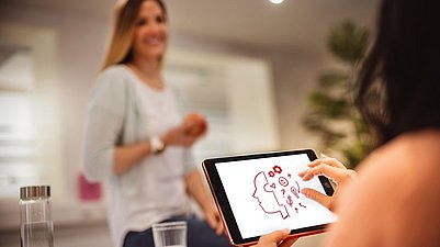 Zwei Studentinnen besprechen ihre Erkenntnisse aus der Gruppenarbeit zur Markenpsychologie.