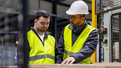 Mann erklärt Mitarbeitendem eine Maschine