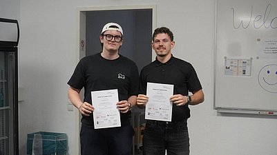 Zwei Männer in einem Klassenzimmer. 