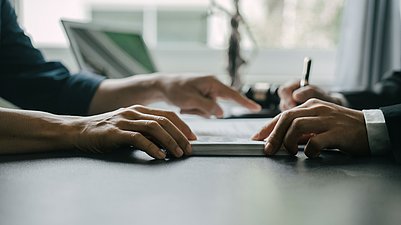 Zwei Personen sitzen am Tisch